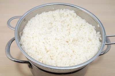Отварной рис откинуть на дуршлаг и дать воде полностью стечь.