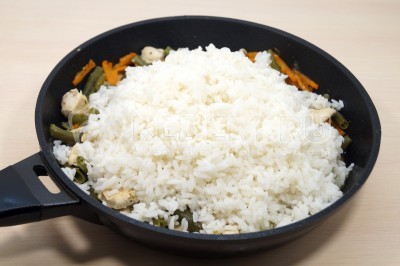Добавить отварной рис в сковороду со стручковой фасолью и курицей. Перемешать.
